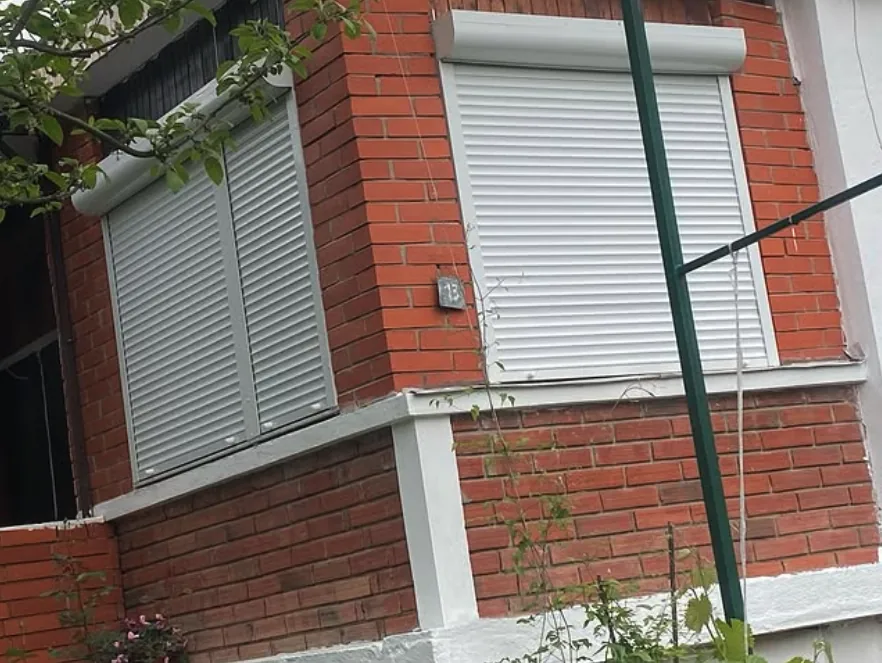 Prozori sa rolo zavesama na fasadi od cigle
